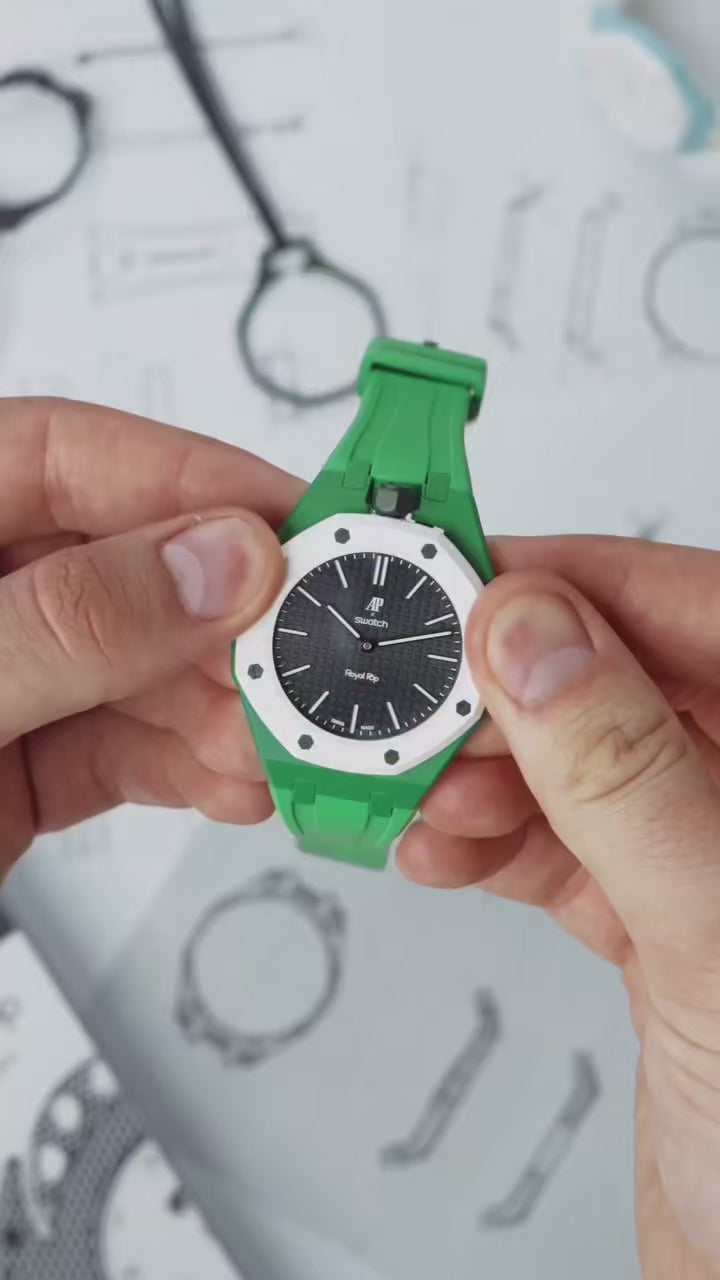 Bracelet Royal Pop vert Maison Brassel en caoutchouc FKM, boîtier intégré à lunette blanche, monté sur une montre AP x Swatch Royal Pop tenue à la main.